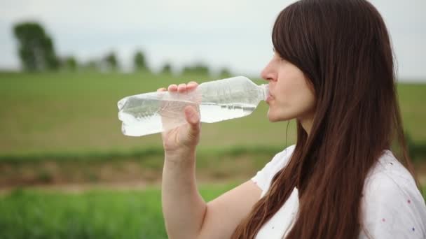 En tjej dricker vatten efter sport — Stockvideo