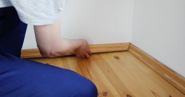 Reparaturen Vorzunehmen Installation Einer Neuen Sockelleiste Ein Mann Repariert Einem — Stockvideo