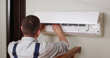 Erkek teknisyen içeride klimayı temizliyor. Yüksek kalite 4k görüntü