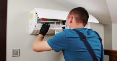 Erkek teknisyen içeride klimayı temizliyor. Yüksek kalite 4k görüntü