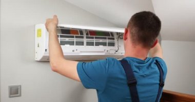 Erkek teknisyen içeride klimayı temizliyor. Yüksek kalite 4k görüntü