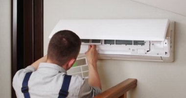 Erkek teknisyen içeride klimayı temizliyor. Yüksek kalite 4k görüntü