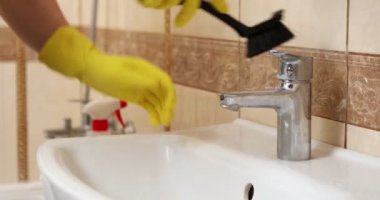 Eldivenli, lavabo ve lavabo musluğu temizleyen kadına yaklaş. Yüksek kalite 4k görüntü