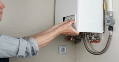 Tesisatçı, Isıtma Cihazları sorununu çözmeye çalışıyor. Gaz kazanının tamiri.