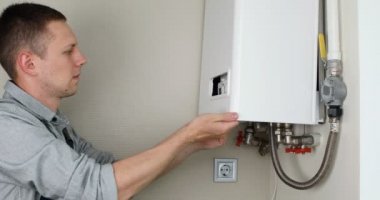 Tesisatçı, Isıtma Cihazları sorununu çözmeye çalışıyor. Gaz kazanının tamiri.