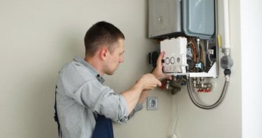 Tesisatçı, Isıtma Cihazları sorununu çözmeye çalışıyor. Gaz kazanının tamiri.