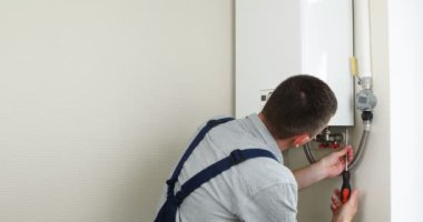 Tesisatçı, Isıtma Cihazları sorununu çözmeye çalışıyor. Gaz kazanının tamiri.