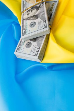 Dolar, Ukrayna bayrağının arka planına karşı. Ukrayna 'daki savaş, tüm dünyadan maddi yardım.