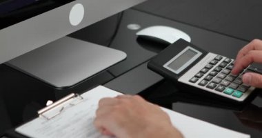 Adam gelir ve giderleri hesaplayan hesap makinesi kullanıyor. Aile bütçesi kavramını yönet.