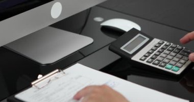 Adam gelir ve giderleri hesaplayan hesap makinesi kullanıyor. Aile bütçesi kavramını yönet.
