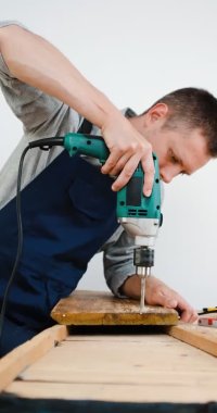 dikey video. Mavi üniformalı tamirci otomatik tornavidayla çalışıyor.. 