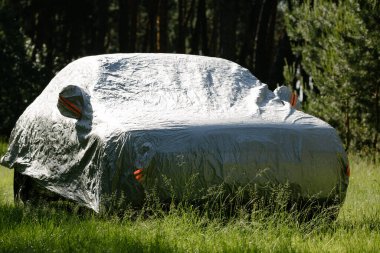 Araba otoparkta, güneşten korunuyor. Arabayı ısıtmaktan koruma..