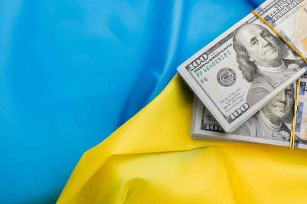 Dolar, Ukrayna bayrağının arka planına karşı. Ukrayna 'daki savaş, tüm dünyadan maddi yardım.