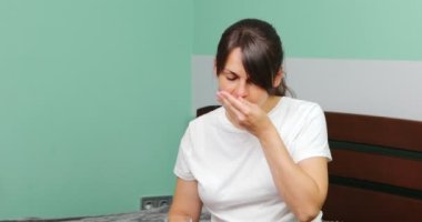 Genç hamile kadın vitamin hapı ve bir bardak su alıyor ve nazikçe karnına dokunuyor.