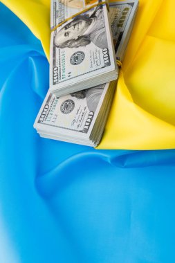 Dolar, Ukrayna bayrağının arka planına karşı. Ukrayna 'daki savaş, tüm dünyadan maddi yardım.