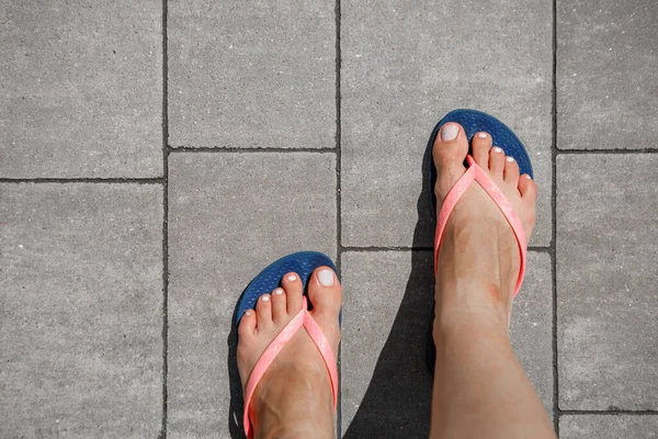 Pies Femeninos Chanclas Sobre Una Baldosa —  Fotos de Stock