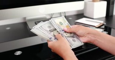 Kadın eli, 100 dolarlık banknotları da sayıyor. Yatırım, para değişimi, rüşvet veya yolsuzluk kavramı.