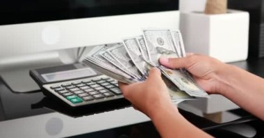 Kadın eli, 100 dolarlık banknotları da sayıyor. Yatırım, para değişimi, rüşvet veya yolsuzluk kavramı.