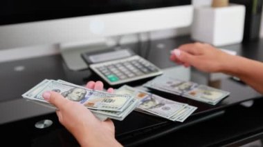 Kadın eli, 100 dolarlık banknotları da sayıyor. Yatırım, para değişimi, rüşvet veya yolsuzluk kavramı.