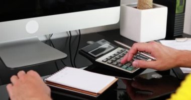 Adam gelir ve giderleri hesaplayan hesap makinesi kullanıyor. Aile bütçesi kavramını yönet.