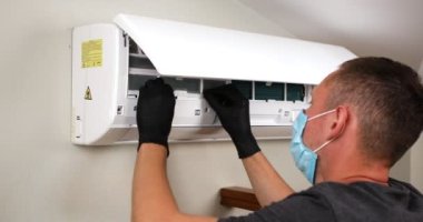 Erkek teknisyen içeride klimayı temizliyor. Yüksek kalite 4k görüntü