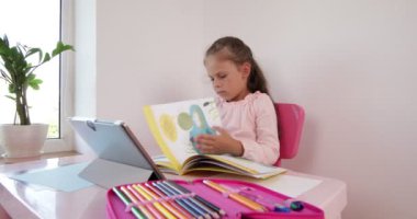 Uzaktan öğrenme çevrimiçi eğitim. Kız evde dijital tablet dizüstü bilgisayarla ders çalışıyor ve ödev yapıyor..