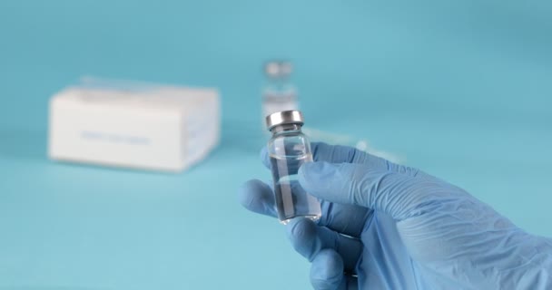 Lekarze Ręcznie Niebieskich Rękawiczkach Trzymają Fiolkę Szczepionką Lub Lekiem Niebieskim — Wideo stockowe