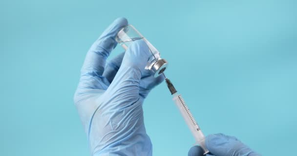 Manos Guantes Médicos Azules Que Extraen Una Jeringa Con Vacuna — Vídeo de stock
