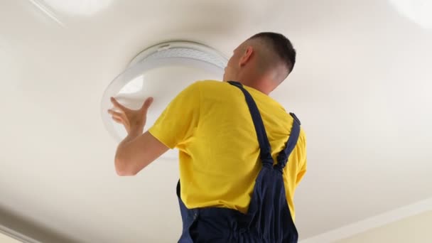 Young Man Electrician Fixing Chandelier Screws Fixing Screw Base Lamp — Wideo stockowe