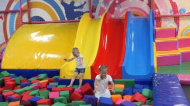 Happy baby riding down slide, childrens play center, kindergarten, funny. High quality 4k footage