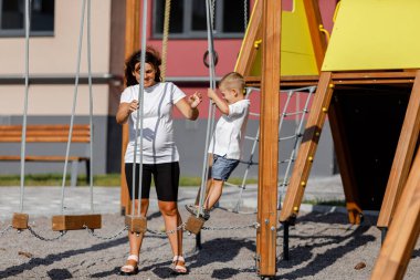 Küçük çocuk ve annesi sokakta oyun oynuyorlar.