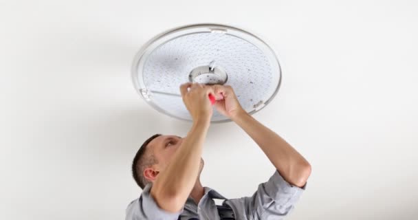 Young Man Electrician Fixing Chandelier Screws Fixing Screw Base Lamp — Vídeo de Stock