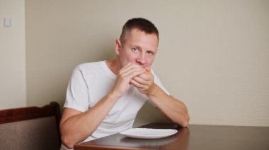 man eating burger at home. High quality FullHD footage