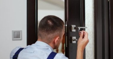 man repairing the doorknob. closeup of workers hands installing new door locker. High quality 4k footage