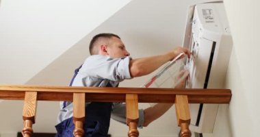 Erkek teknisyen içeride klimayı temizliyor. Yüksek kalite 4k görüntü