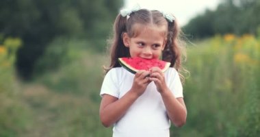 Happy childhood concept. Girl eating watermelon slices sunny summer day. High quality 4k footage