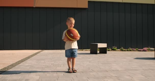 Boy Holds Basketball Sports Ground Dwelling Houses High Quality Footage — Stockvideo