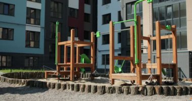 modern children playground in courtyard of high-rise residential buildings in sunny summer day. High quality 4k footage