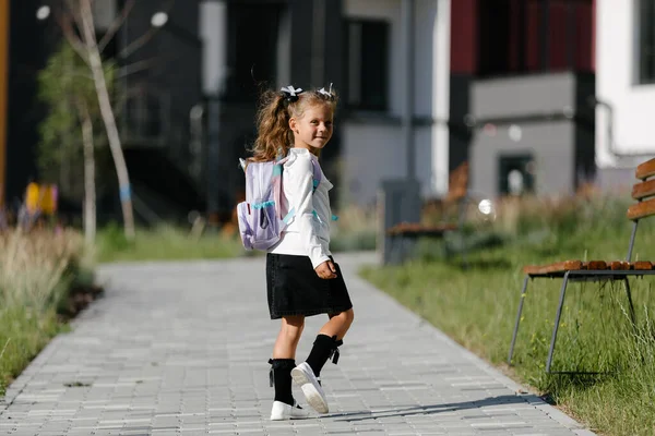 a little girl goes to school through the park along the path. distance education concept.