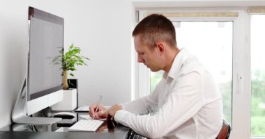 businessman using computer remote distance working sitting at table writing notes. Student studying online, having virtual digital training on laptop at home office