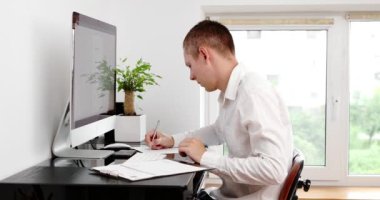 businessman using computer remote distance working sitting at table writing notes. Student studying online, having virtual digital training on laptop at home office