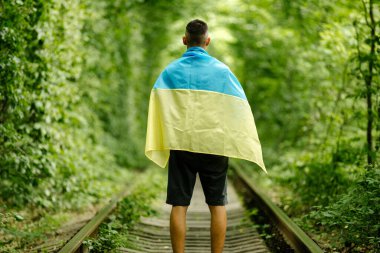 Adam ellerini kaldırdı ve Ukrayna bayrağını arkasına aldı. Ukraynalı vatansever konsepti, Ukrayna 'yı desteklemek için miting