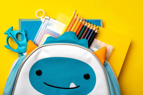 Rucksack Mit Schulmaterial Auf Blauem Und Gelbem Hintergrund Blick Von — Stockfoto