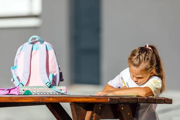 책가방을 미소를 노트를 읽으며 거리에서 숙제를 여학생 — 스톡 사진