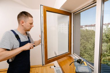 İşçi eve pencere kurup kontrol ediyor.