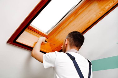 İşçi eve pencere kurup kontrol ediyor.