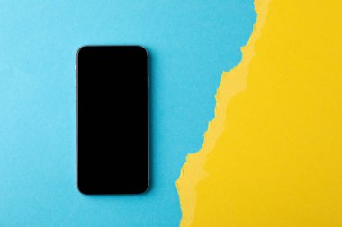 Ukrayna bayrağının arka planında boş ekran cep telefonu.