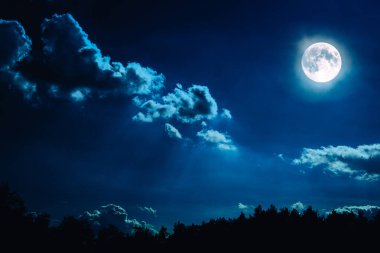 Gece gökyüzünde yıldızlar ve dolunay arka plan ile.