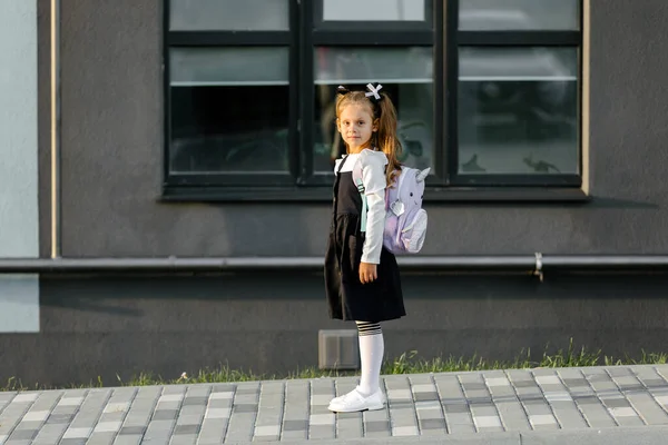 a little girl goes to school through the park along the path. distance education concept. school girl returning home from school