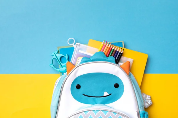 Mochila Con Útiles Escolares Sobre Fondo Azul Amarillo Vista Desde —  Fotos de Stock